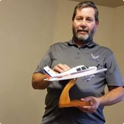 gallery image of satisfied customer holding a training aircraft model
