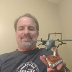 gallery image of satisfied customer holding a custom aircraft model mounted to a triangular fuselage mount stand