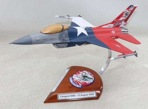 F‑16C model in red, white, and blue 75th anniversary paint with tail number 86‑0246 on stand with 457th Fighter Sq emblem