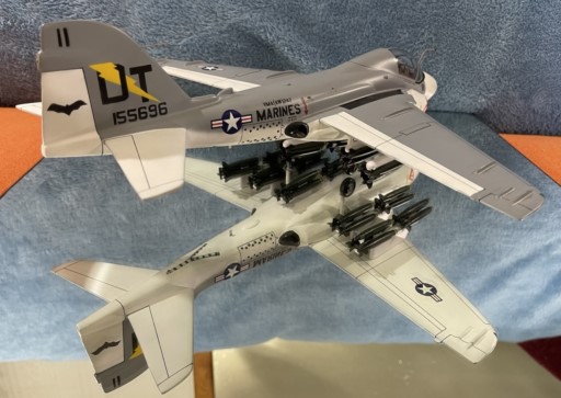 Marine A‑6A Intruder model in gray with tail code DT, bat symbol, and full bomb and missile loadout under wings