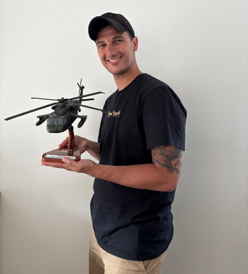Person holding wooden aircraft model on display base