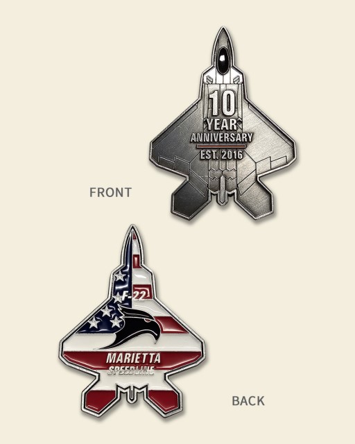 Lockheed Martin Marietta Speedline F-22 challenge coin showing aircraft-shaped design with American flag details and 10-year anniversary engraving.