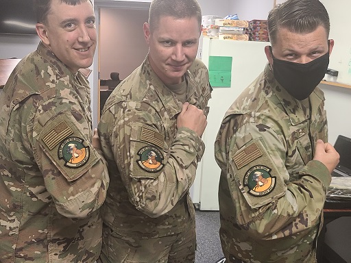 Three Airmen in uniform, each wearing 20 MXG MOC Section Morale Patch on right arm