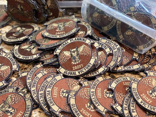 Multiple 6 LRS Global Victory OCP Patches spread out on surface, some inside clear plastic bag