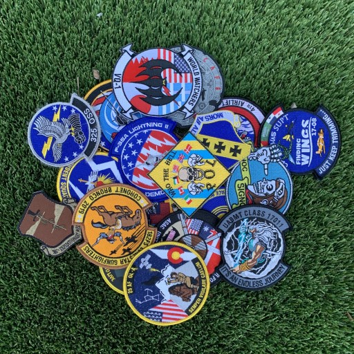 Colorful military patches arranged on grass showing symbolic use of color
