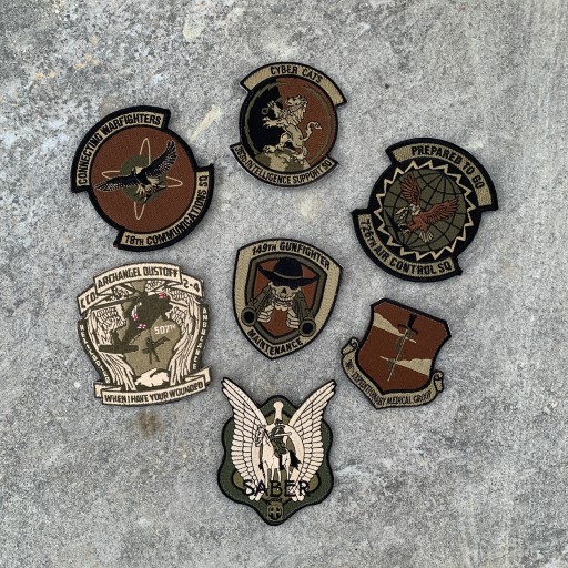 Military patches with eagles, swords, and unit symbols representing mission and identity