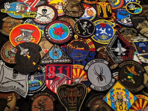 Collection of military patches showing diverse heraldry traditions across branches