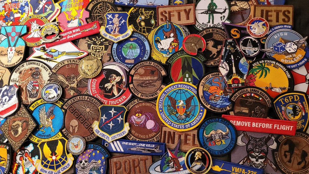 Collection of custom military patches coins and key flags showing Aviator Gear'99s design craftsmanship
