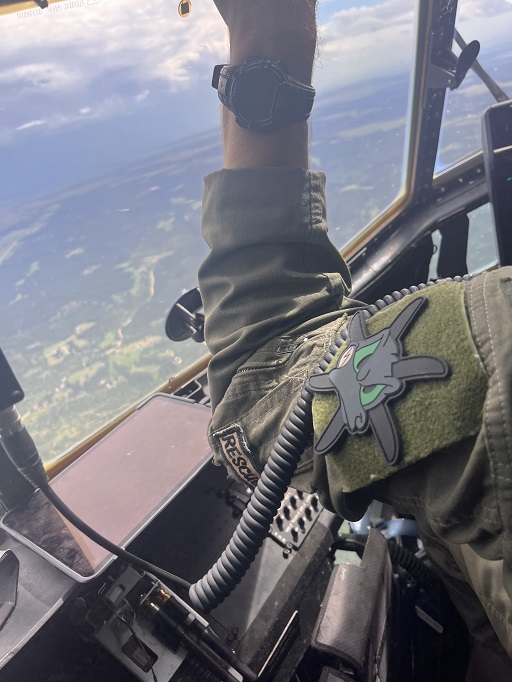 Airman in flight suit seated in cockpit wearing 415th Special Operations Squadron PVC patch on sleeve