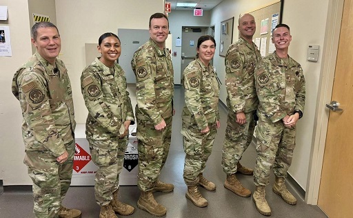 Group of airmen in hallway wearing uniforms with 436th Healthcare Operations Squadron Pharmacy OCP patch