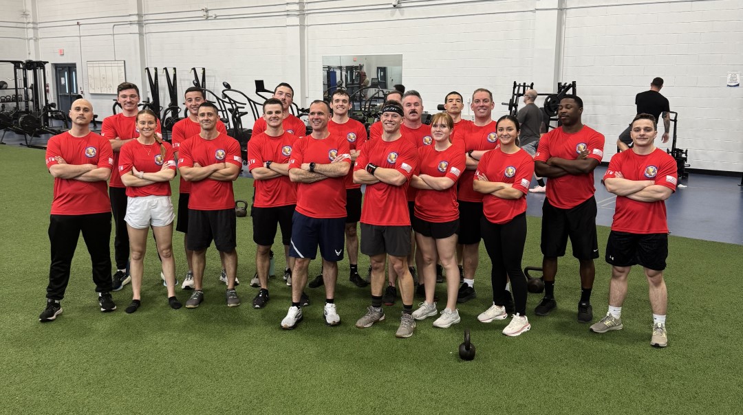 Airmen wearing matching 15th Airlift Squadron morale t‑shirts in unit colors