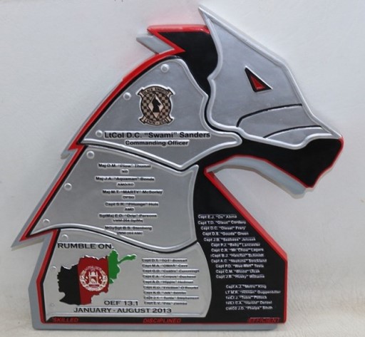 Miniature VMM‑264 deployment plaque held by a service member as a commemorative keepsake