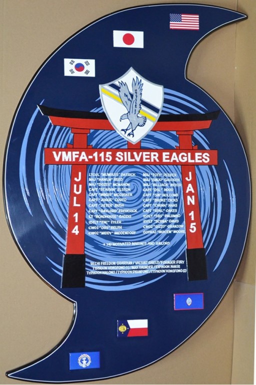 VMFA‑115 deployment plaque featuring squadron insignia, flags, names of personnel, and mission details