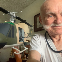 gallery image of satisfied customer with mustache holding a helicopter model