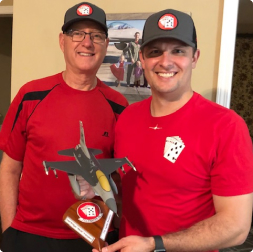 gallery image of a man holding a gifted aircraft model next to his father